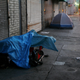 People sleep on the sidewalk in Los Angeles, California, on April 19, 2006.
